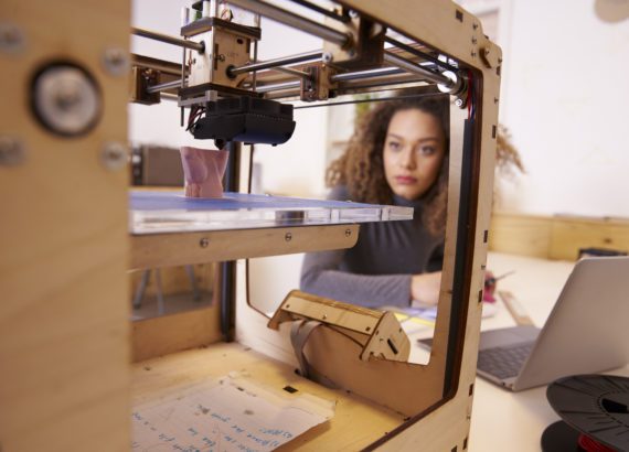 Female artist uses a 3D printer for a design.