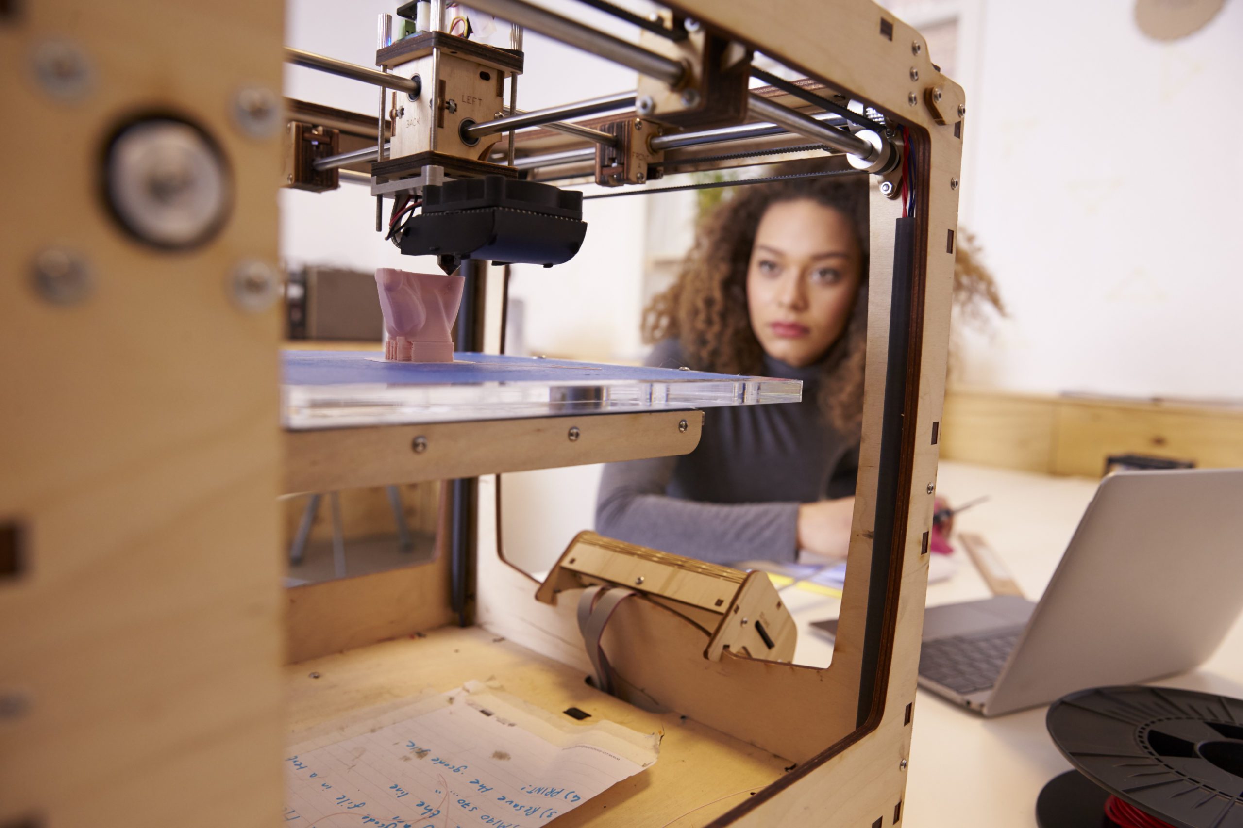 Female artist uses a 3D printer for a design.