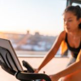 Women uses her smart gym bike in her home.