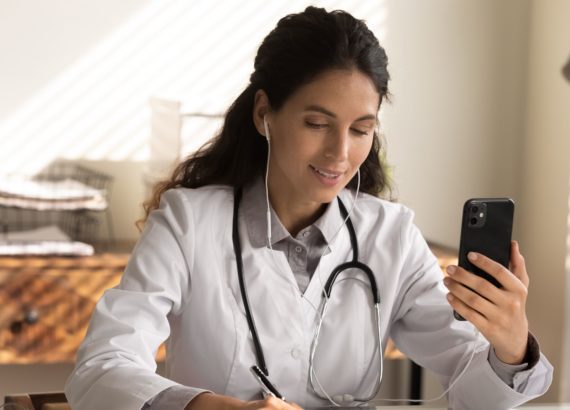 A physician uses her phone for a telemedicine appointment.