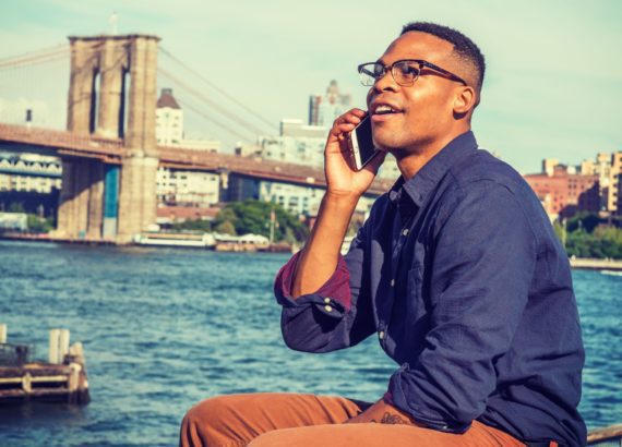 A man enjoys a sunny day in New York, which is a smart city. 