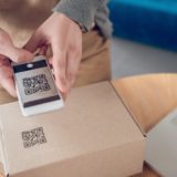 A person scans a QR code on a package.