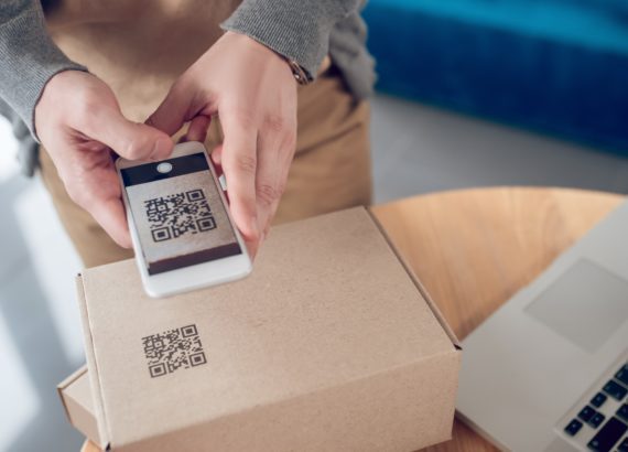 A person scans a QR code on a package.
