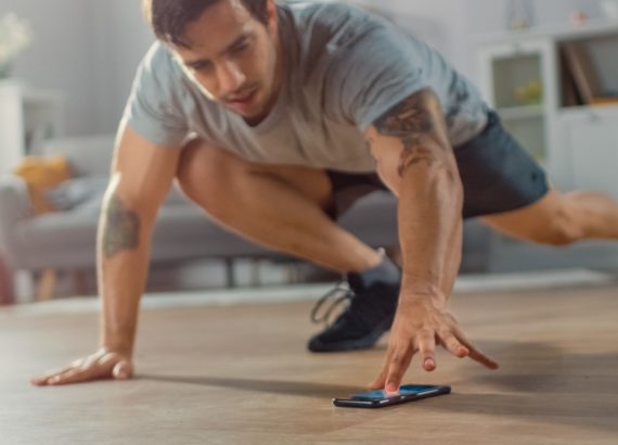 A man logs his workout on an behavior modification app on his smartphone. 