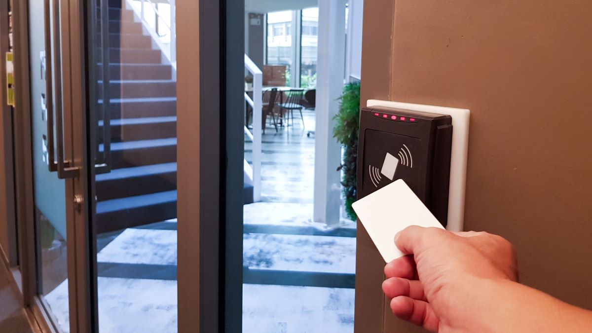 A resident uses a key card to enter an apartment building.