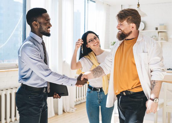 A leasing staff agent shakes hands with a new renter.