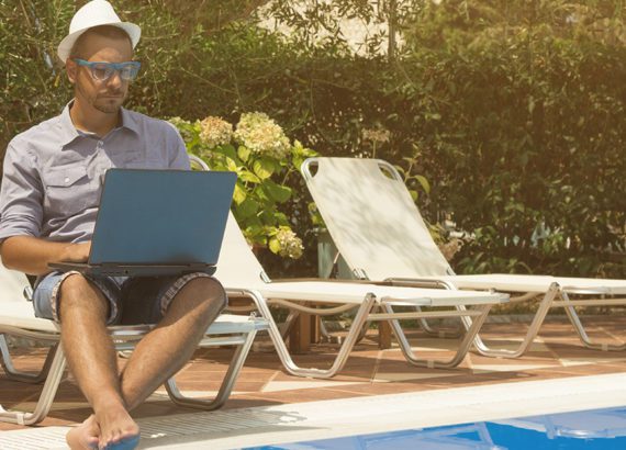 Resident sits beside the pool at his apartment using community-wide WiFi.