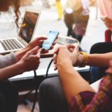 friends using WiFi 6 on laptop, phone, and tablet