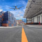 airplane flying near large buildings delivering products to combat supply chain issues