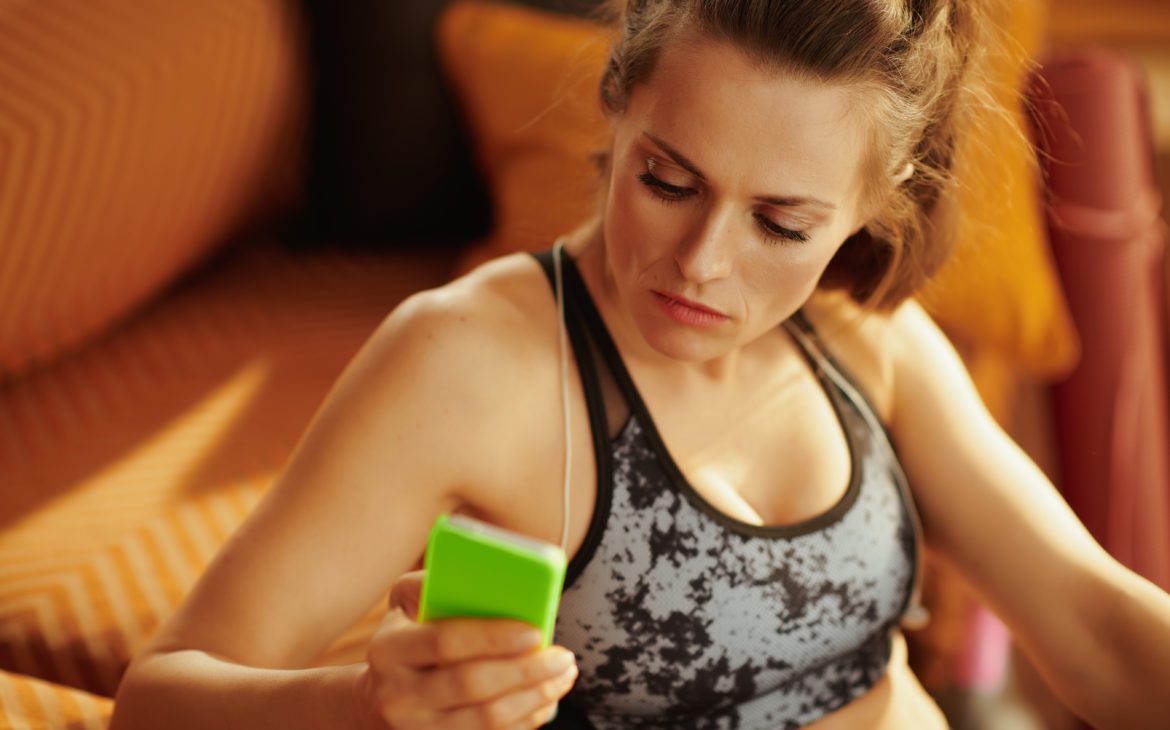 athletic woman looking for cool tech gifts on her phone