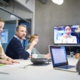 A group of people discuss the potential of multifamily development at a conference table.