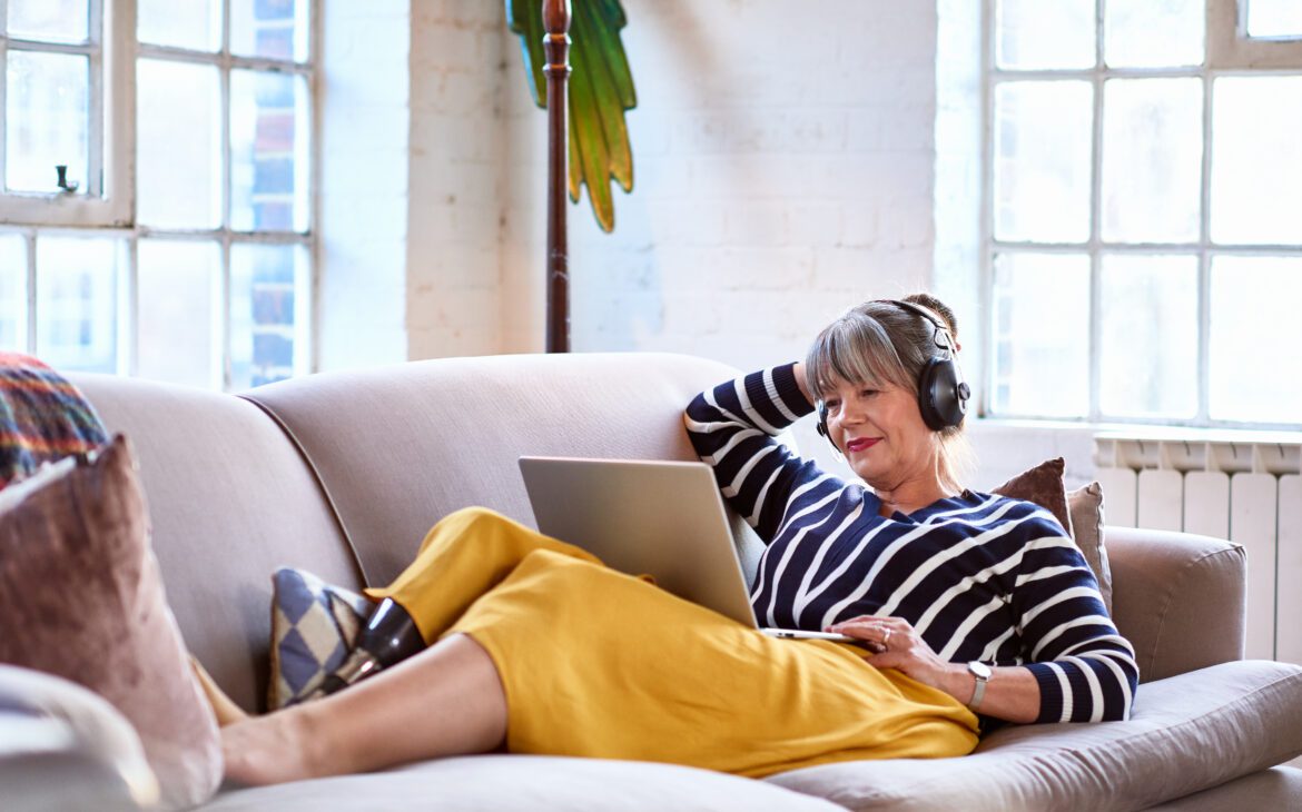 A woman relaxes and streams music after a successful retrofitting project.