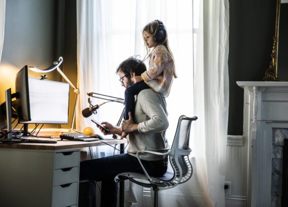 Dad working from home with daughter on shoulders