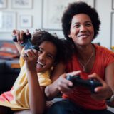 A mother and daughter play games together, enjoying their mother's day tech gifts.