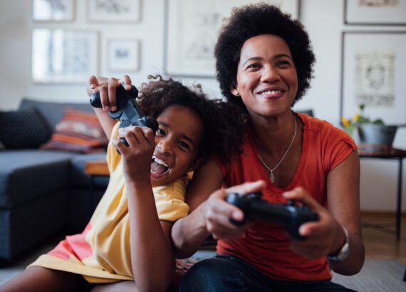 A mother and daughter play games together, enjoying their mother's day tech gifts.