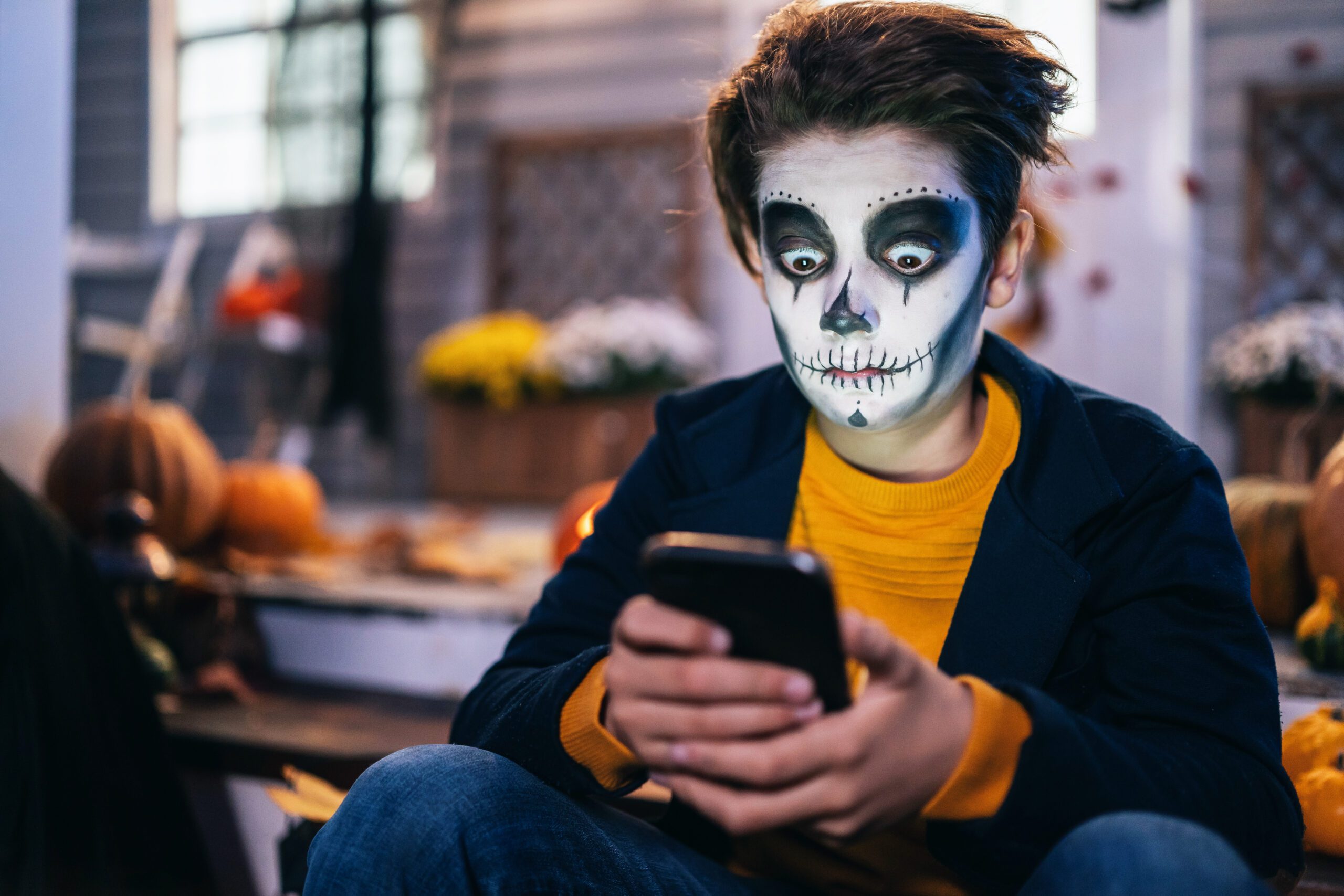 Boy dressed as a zombie using zombie computer