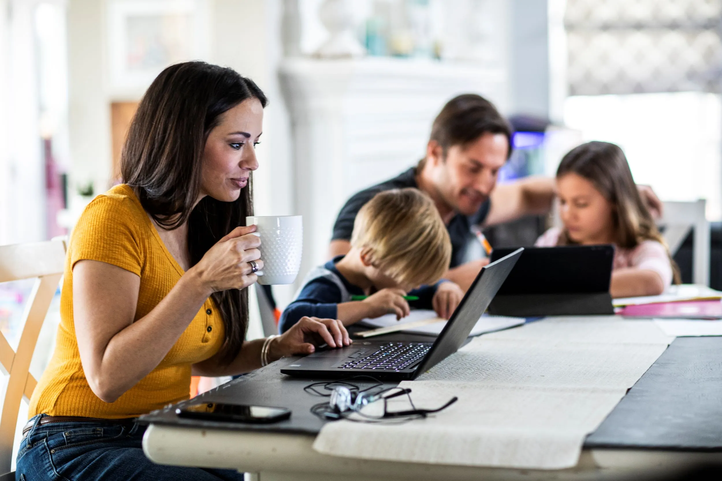 Family at kitchen tablet looking at devices