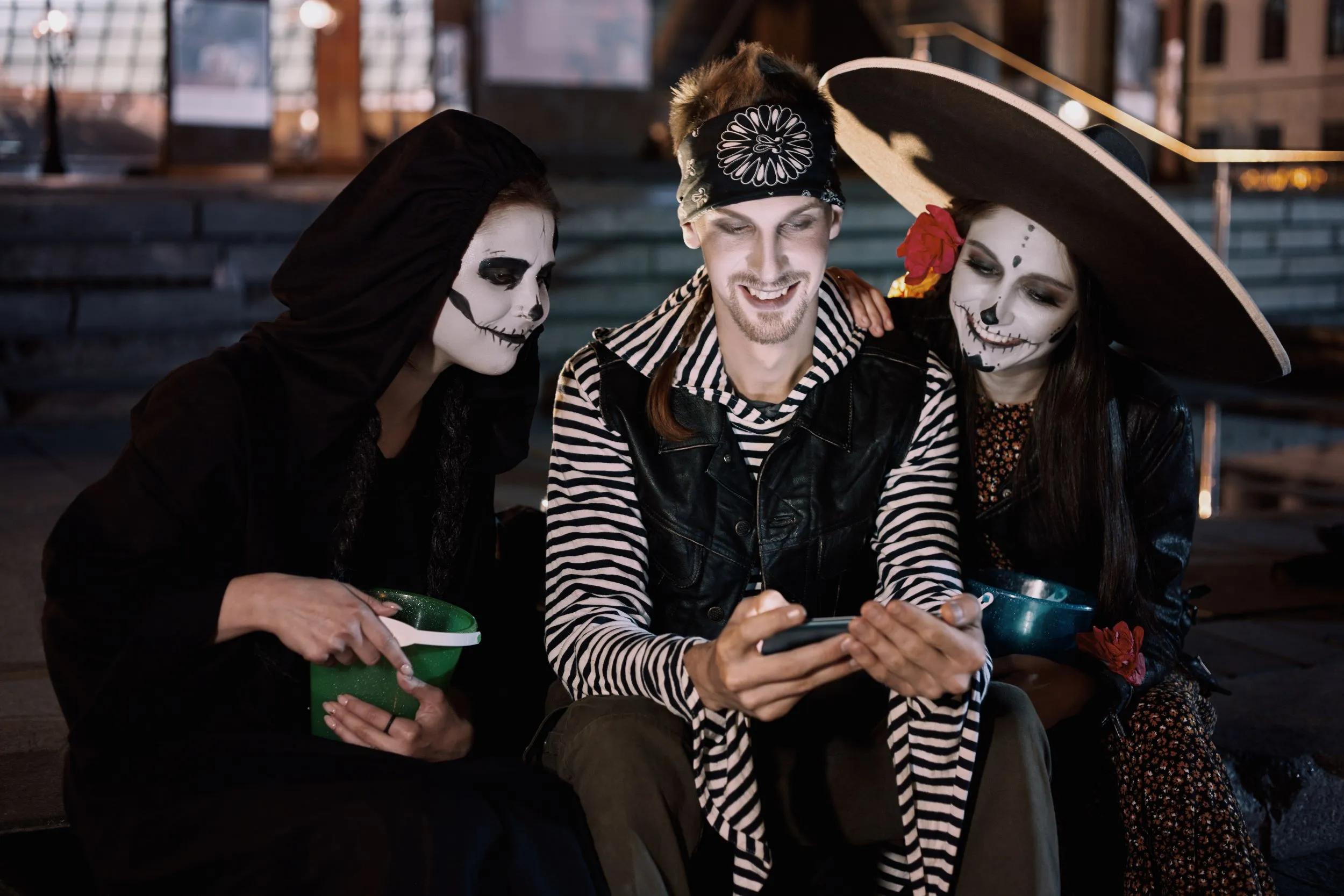 Teens in halloween costumes looking at their mobile device