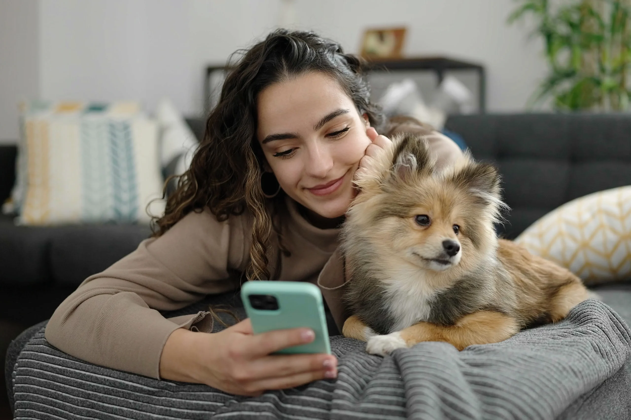 Lady with dog while looking at mobile phone apps