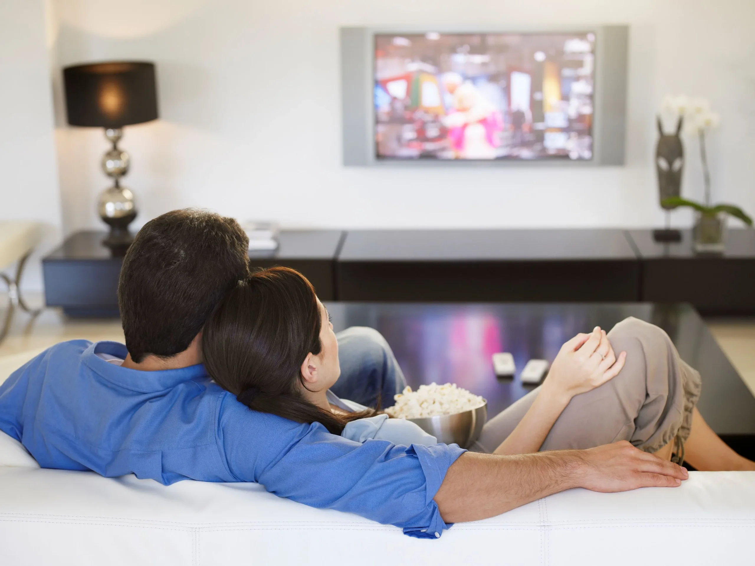 Couple streaming movie in living room.