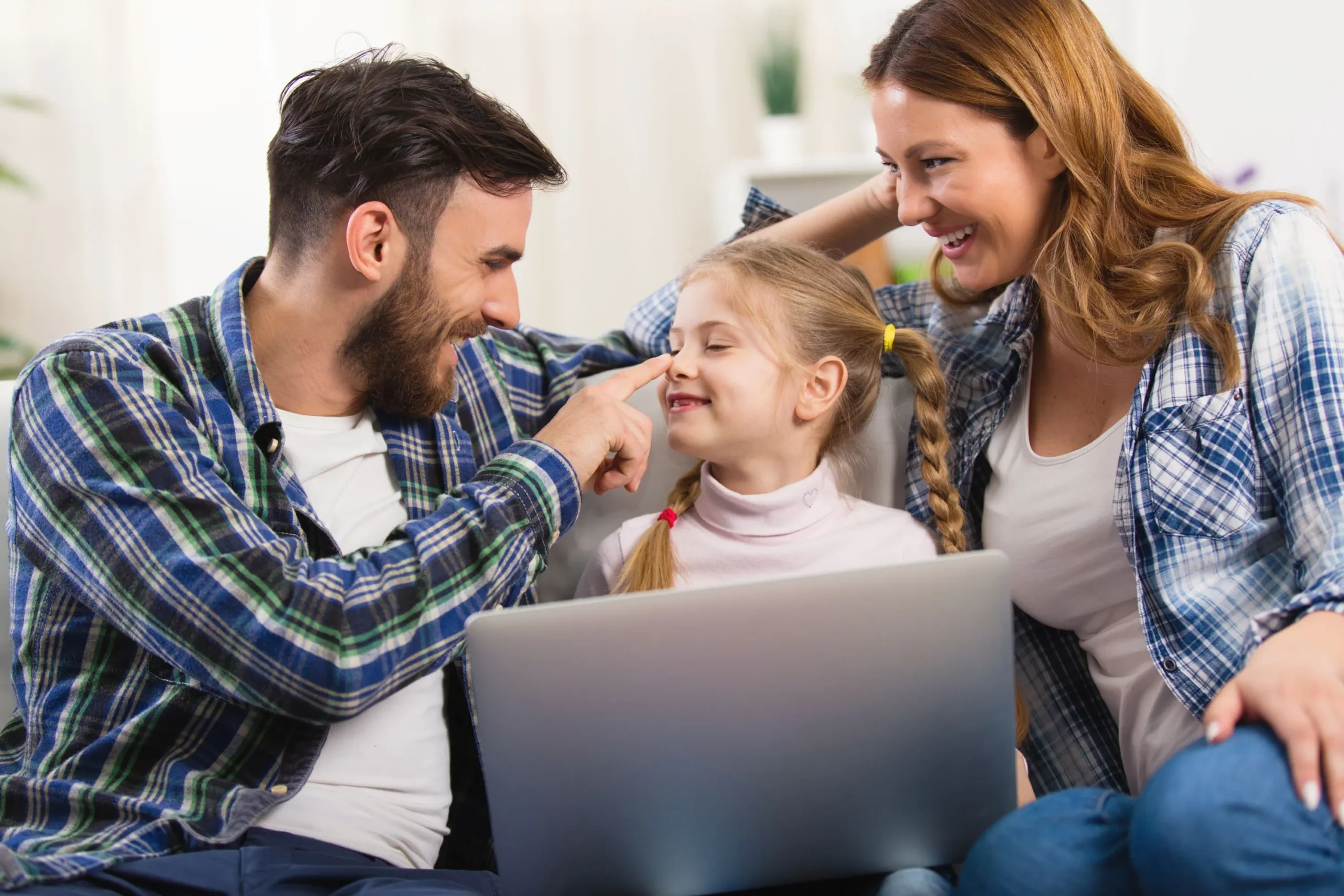 Family on couch using laptop