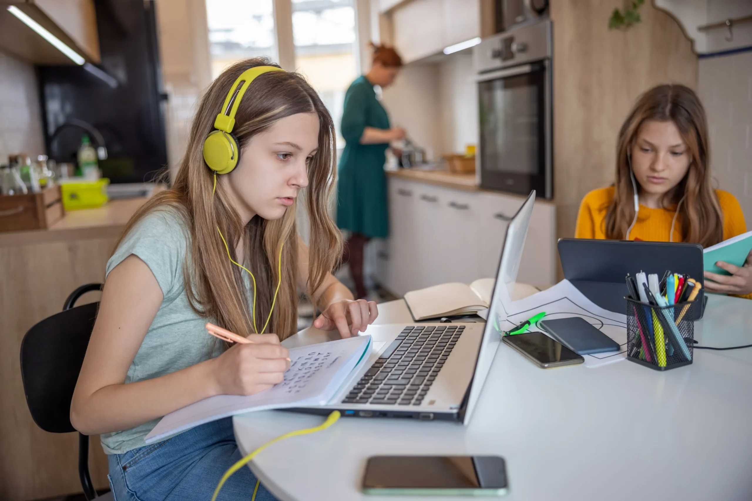 mom-in-kitchen-with-2-daughters-studying