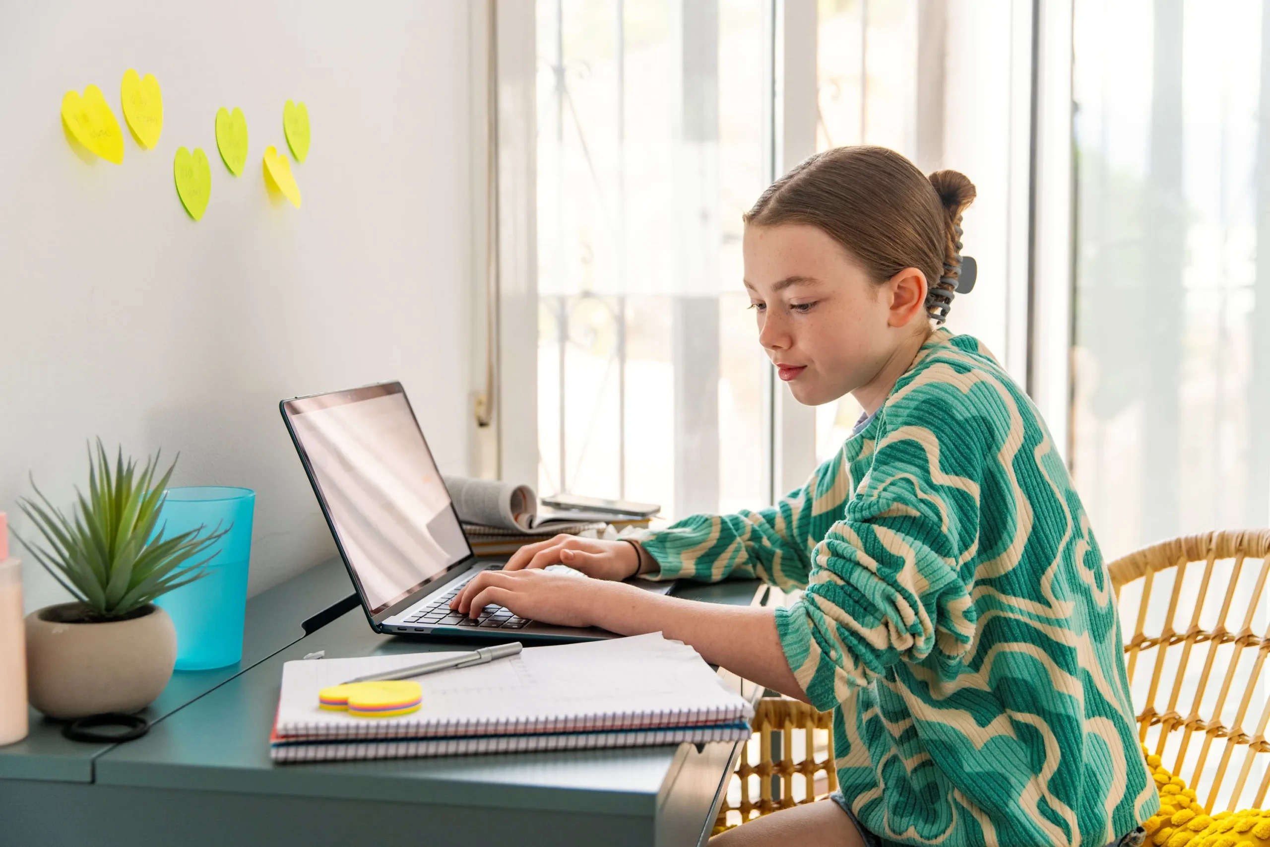 Young girl doing school work on computer at desk