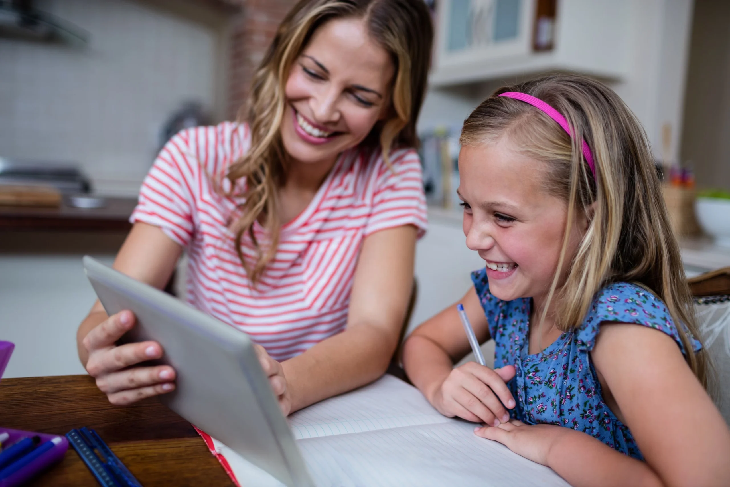 Woman and girl doing work on a tablet