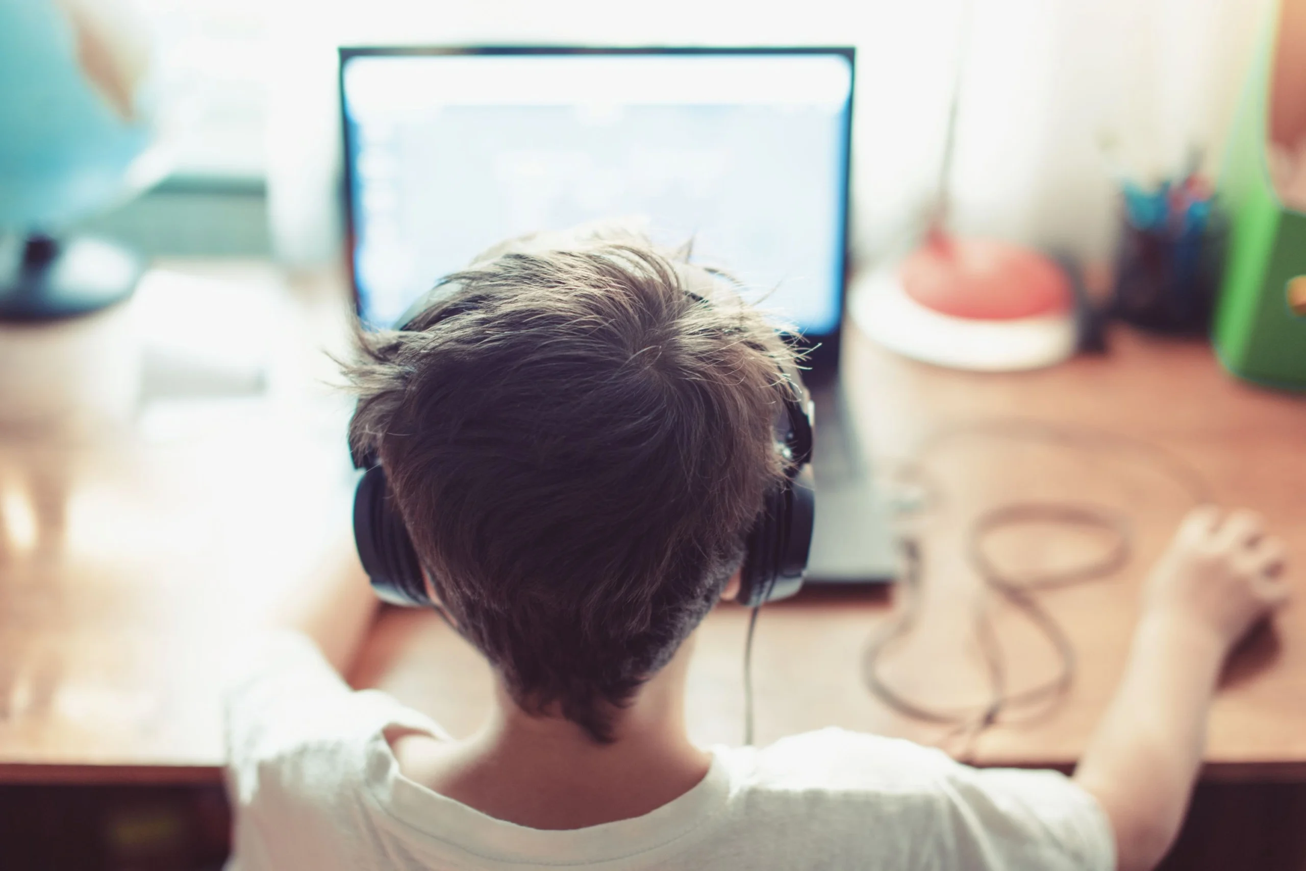 boy with headphones looking at computer screen