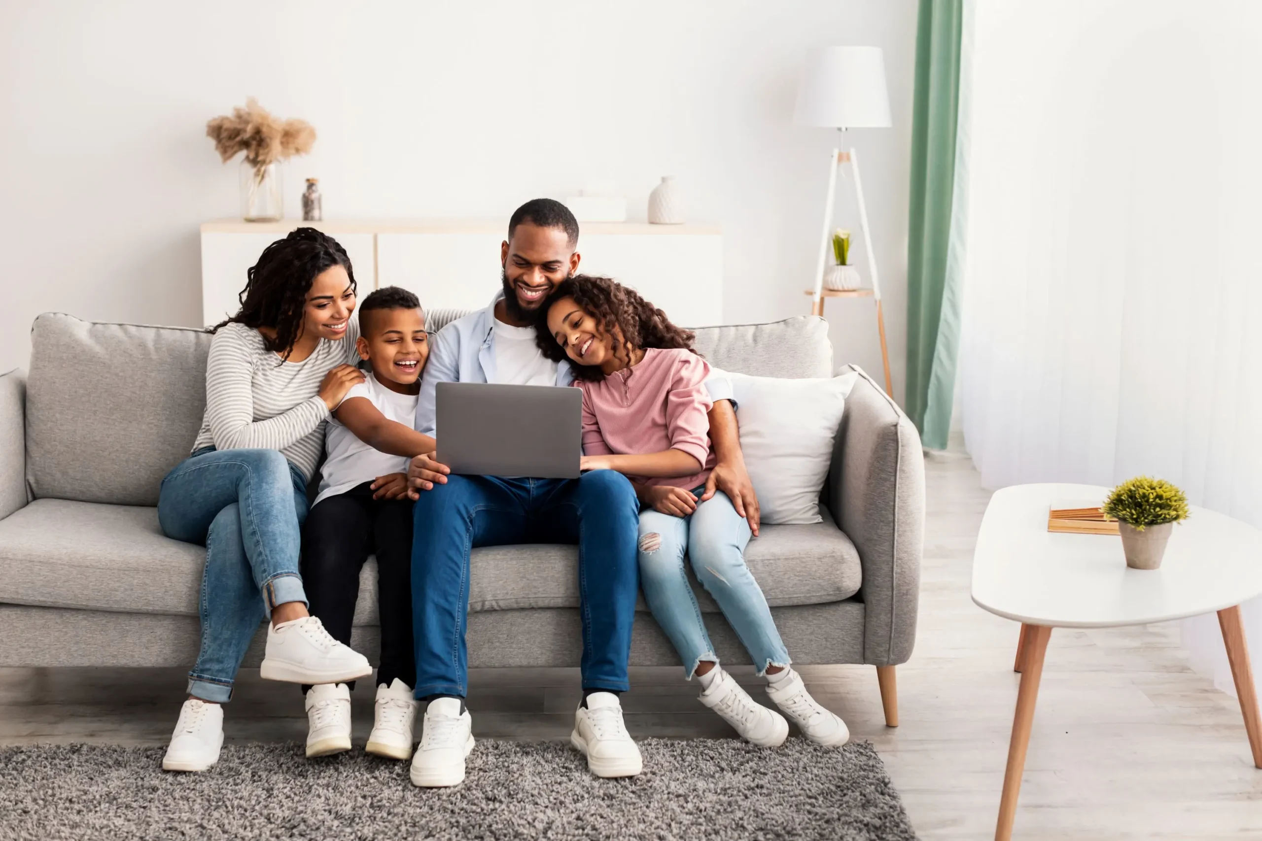 family-sitting-on-couch-with-device