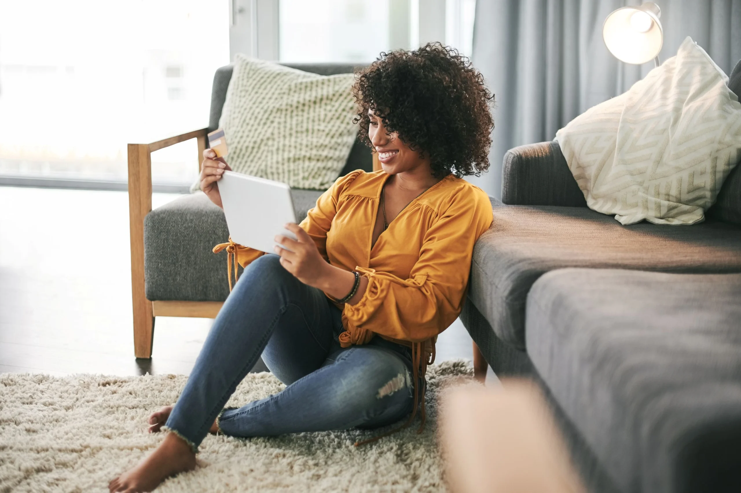 woman-sitting-on-floor-with-credit-card-and-tablet