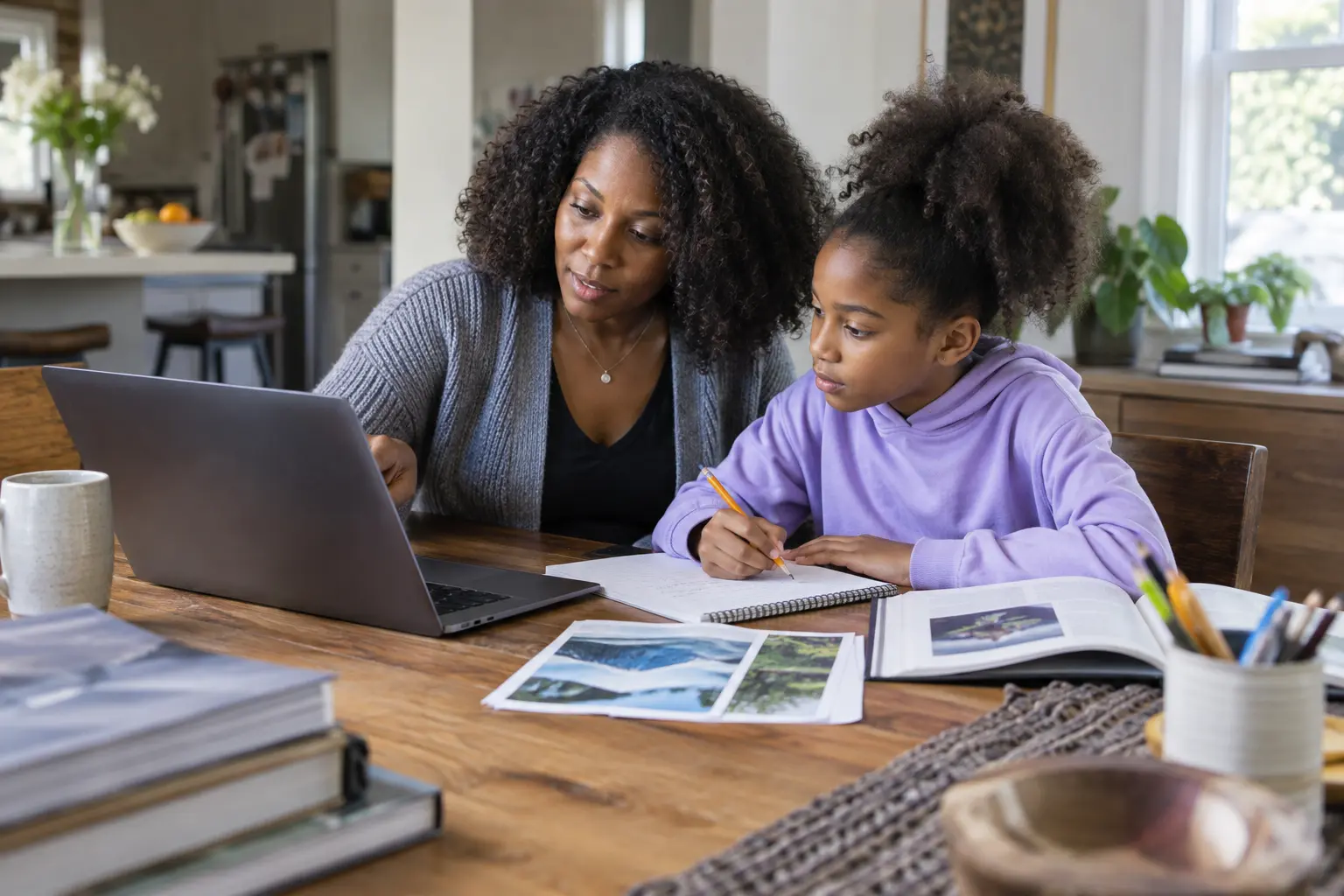 Parent and child use a laptop, books, and notes to research a school project together at home.